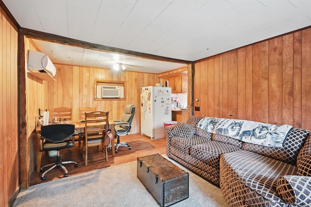 23 Main St, Athens, ME 04912 - living area featuring wood walls, an AC wall unit, a desk, and light wood-style flooring
