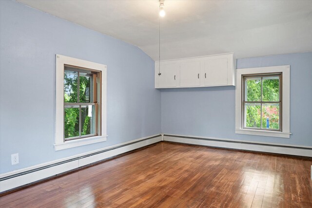 133 Front St, Old Town, ME 04468 - empty room featuring a baseboard radiator, healthy amount of natural light, wood finished floors, and lofted ceiling