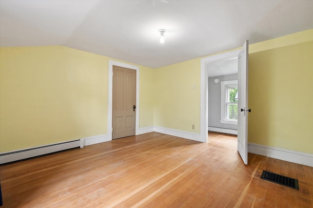 133 Front St, Old Town, ME 04468 - unfurnished room with a baseboard radiator, light wood-style flooring, and lofted ceiling