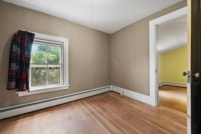133 Front St, Old Town, ME 04468 - spare room featuring a baseboard radiator, wood finished floors, and vaulted ceiling