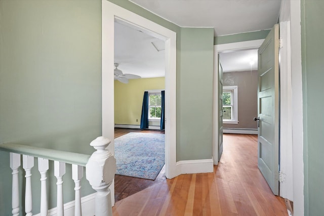 133 Front St, Old Town, ME 04468 - hall featuring plenty of natural light, wood finished floors, and a baseboard heating unit