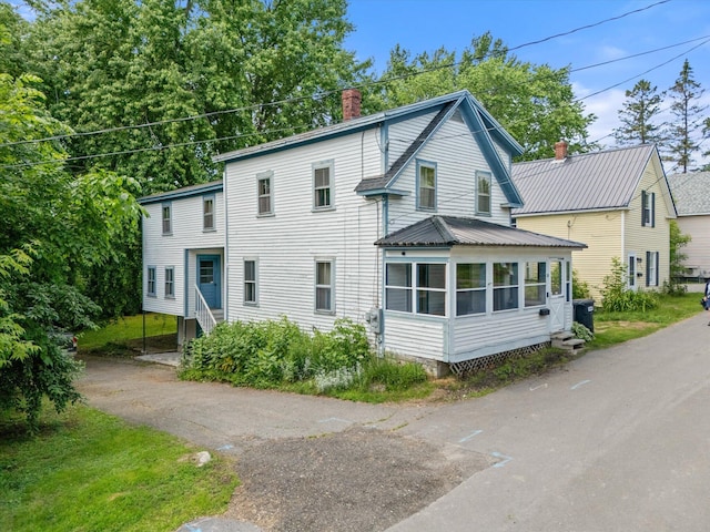 133 Front St, Old Town, ME 04468 - view of front of house with a chimney, asphalt driveway, a sunroom, and entry steps