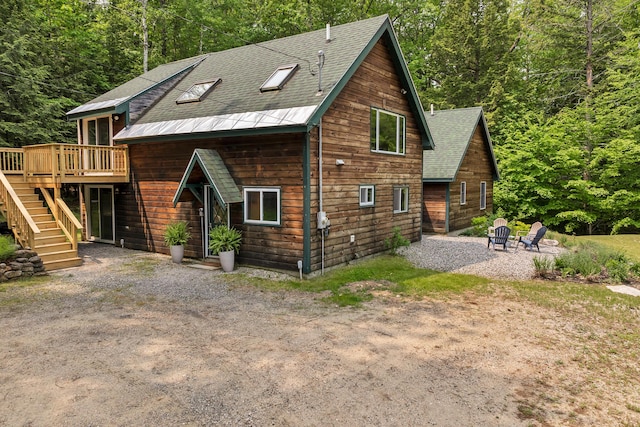 12 Michaud Ln, Bridgton, ME 04009 - rear view of house featuring a deck, stairway, a patio, a shingled roof, and a forest view