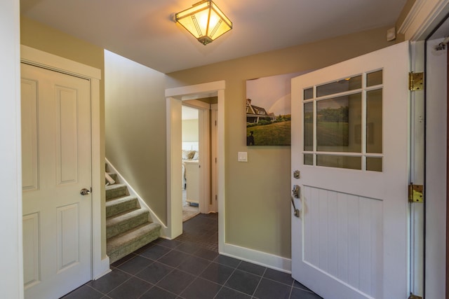 321 Beech Hill Rd, Northport, ME 04849 - entrance foyer with dark tile patterned flooring, stairway, and baseboards