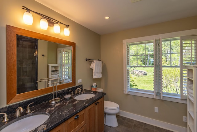 321 Beech Hill Rd, Northport, ME 04849 - full bathroom featuring double vanity, toilet, baseboards, tile patterned flooring, and a tile shower