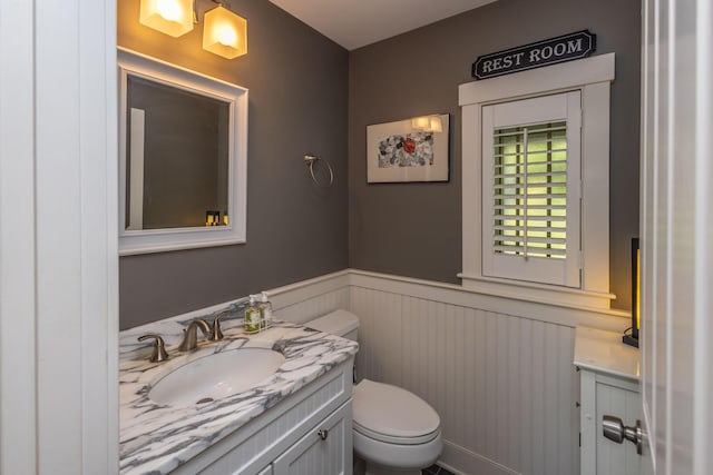 321 Beech Hill Rd, Northport, ME 04849 - bathroom featuring a wainscoted wall, vanity, and toilet