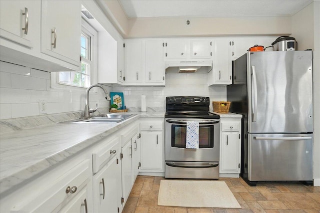 46 Jeffrey St, Lewiston, ME 04240 - kitchen with stainless steel appliances, under cabinet range hood, a sink, stone tile flooring, and white cabinetry