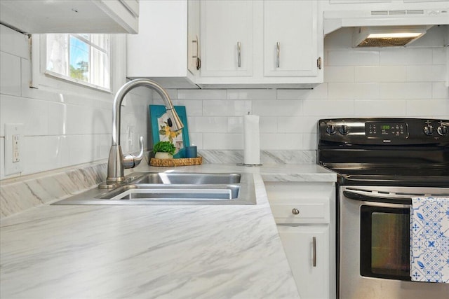 46 Jeffrey St, Lewiston, ME 04240 - kitchen with stainless steel range with electric stovetop, under cabinet range hood, a sink, decorative backsplash, and white cabinets