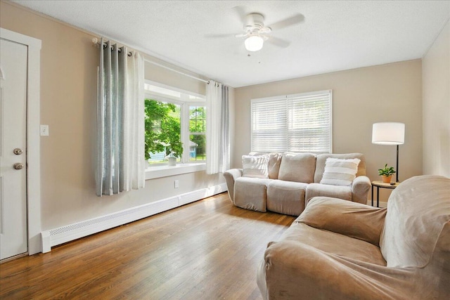 46 Jeffrey St, Lewiston, ME 04240 - living room featuring ceiling fan, wood finished floors, a baseboard radiator, and baseboards