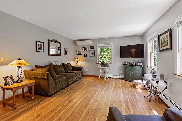 11 Lewis Rd, Sidney, ME 04330 - living room with an AC wall unit, light wood-style floors, baseboards, and a baseboard radiator