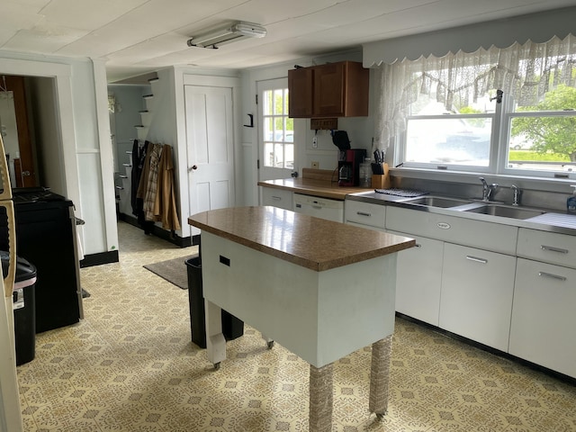 13 Main St, Cambridge, ME 04923 - kitchen with a sink, dark countertops, white cabinetry, dishwasher, and light flooring