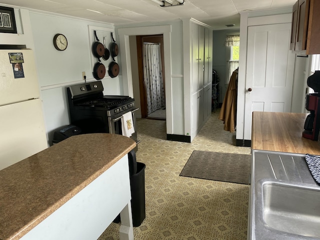 13 Main St, Cambridge, ME 04923 - kitchen featuring freestanding refrigerator, light floors, a sink, stainless steel gas range oven, and dark countertops