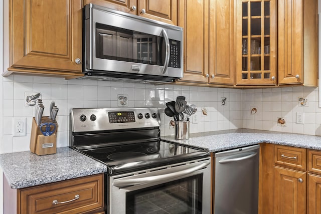 60 Barrell Ln Unit 1, York, ME 03909 - kitchen featuring stainless steel appliances, brown cabinetry, glass insert cabinets, and tasteful backsplash