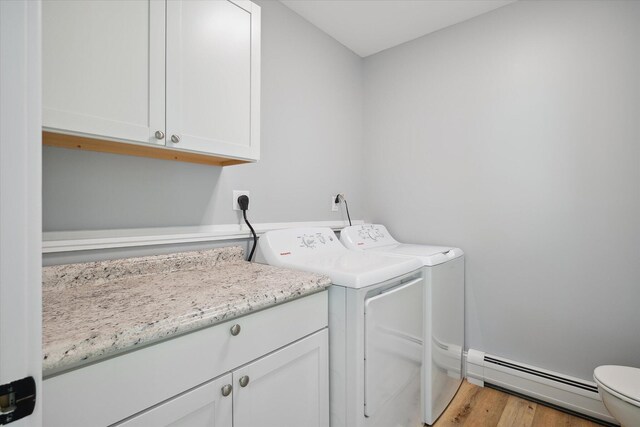 45 Doughty Blvd, Levant, ME 04456 - laundry area with a baseboard radiator, separate washer and dryer, wood finished floors, and cabinet space