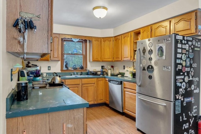 32 Milky Way Ln, Durham, ME 04222 - kitchen featuring appliances with stainless steel finishes, a sink, light wood-style floors, brown cabinetry, and dark countertops