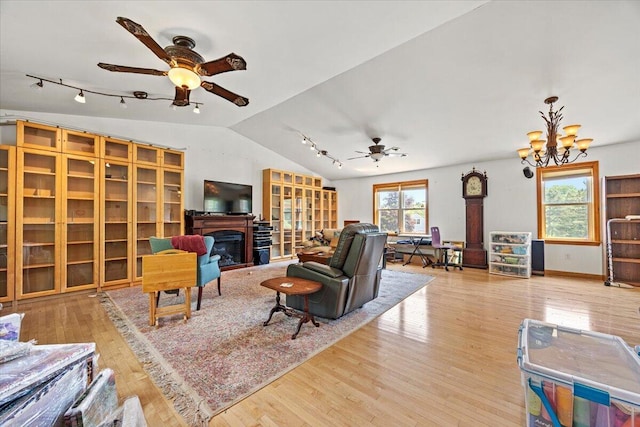 2 Blueberry Pines Dr, Kennebunk, ME 04043 - living area with a ceiling fan, wood finished floors, vaulted ceiling, a fireplace, and rail lighting