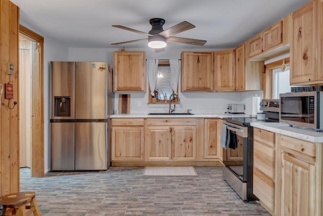 41 Sunny Ln, Sanford, ME 04073 - kitchen with stainless steel appliances, a sink, light brown cabinetry, a ceiling fan, and light countertops