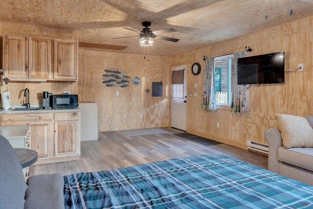 41 Sunny Ln, Sanford, ME 04073 - living room featuring baseboard heating, wooden walls, a ceiling fan, light wood-style floors, and electric panel