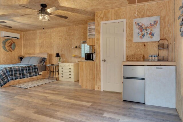 41 Sunny Ln, Sanford, ME 04073 - bedroom with a wall mounted AC, freestanding refrigerator, wood walls, wood finished floors, and attic access