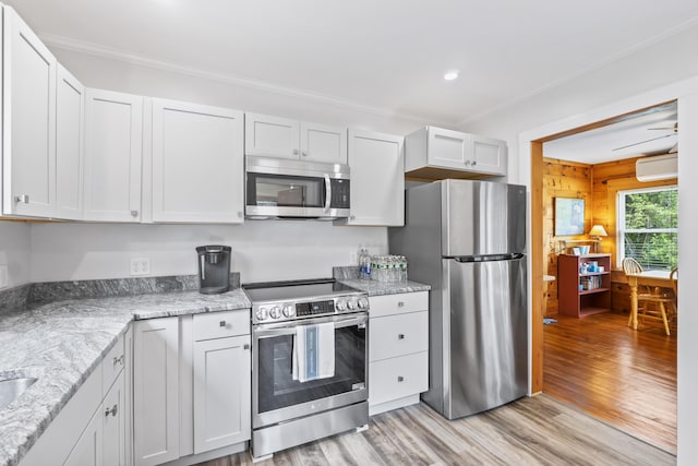 82 Littlefield Rd, Wells, ME 04090 - kitchen with appliances with stainless steel finishes, a wall unit AC, light wood finished floors, crown molding, and light stone counters