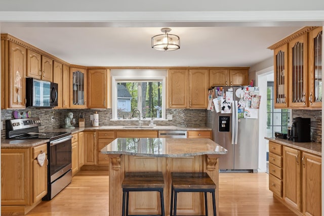 47 Old Post Ln, Sanford, ME 04073 - kitchen with appliances with stainless steel finishes, a sink, light wood-style floors, light stone countertops, and tasteful backsplash