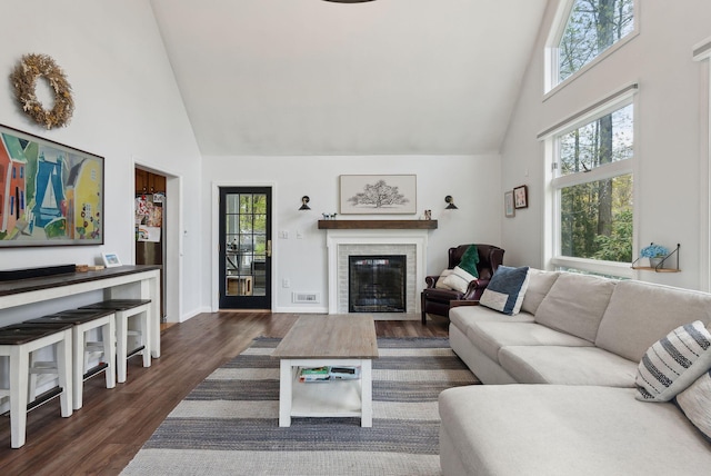 47 Old Post Ln, Sanford, ME 04073 - living room with high vaulted ceiling, plenty of natural light, wood finished floors, a brick fireplace, and baseboards