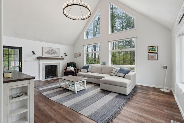 47 Old Post Ln, Sanford, ME 04073 - living room with high vaulted ceiling, a fireplace, dark wood finished floors, a chandelier, and baseboards