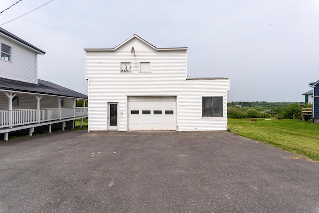 982 Main St, Grand Isle, ME 04746 - view of front of home featuring asphalt driveway, a front yard, and a garage