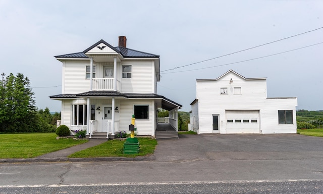 982 Main St, Grand Isle, ME 04746 - view of front of property with a garage, a chimney, metal roof, a standing seam roof, and driveway