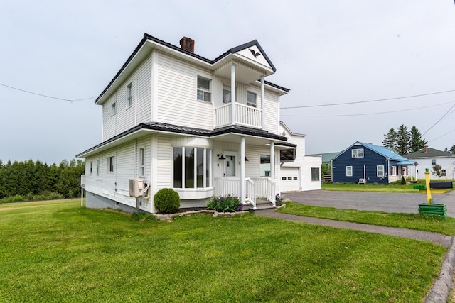 982 Main St, Grand Isle, ME 04746 - view of front of property featuring a chimney, a balcony, a front yard, asphalt driveway, and cooling unit