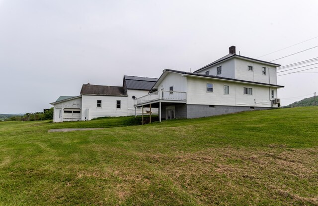 982 Main St, Grand Isle, ME 04746 - back of property with a lawn, a garage, and a chimney