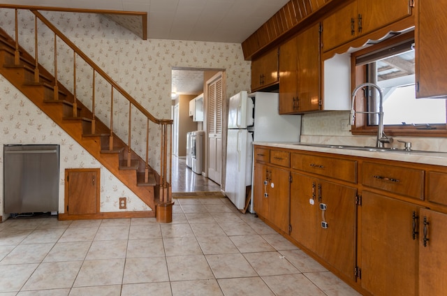 982 Main St, Grand Isle, ME 04746 - kitchen featuring wallpapered walls, light countertops, a sink, washer / clothes dryer, and brown cabinetry