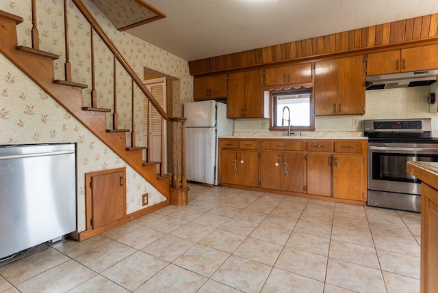 982 Main St, Grand Isle, ME 04746 - kitchen with stainless steel appliances, under cabinet range hood, wallpapered walls, light countertops, and a sink