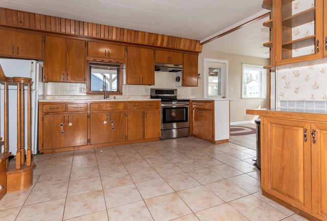 982 Main St, Grand Isle, ME 04746 - kitchen featuring stainless steel range with electric cooktop, under cabinet range hood, brown cabinets, light countertops, and freestanding refrigerator