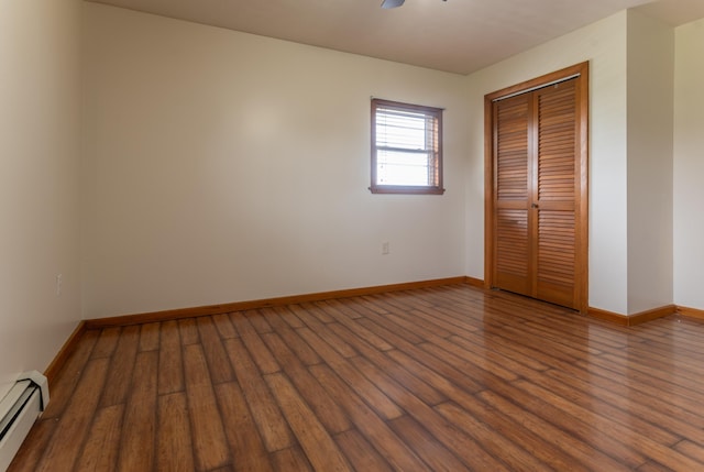 982 Main St, Grand Isle, ME 04746 - unfurnished bedroom with a baseboard radiator, wood finished floors, a closet, and baseboards