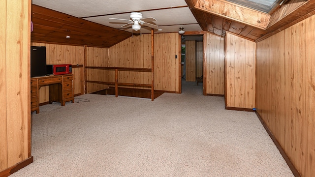 20 Rabbit Ln, Naples, ME 04055 - additional living space with vaulted ceiling, wooden walls, a ceiling fan, a skylight, and carpet