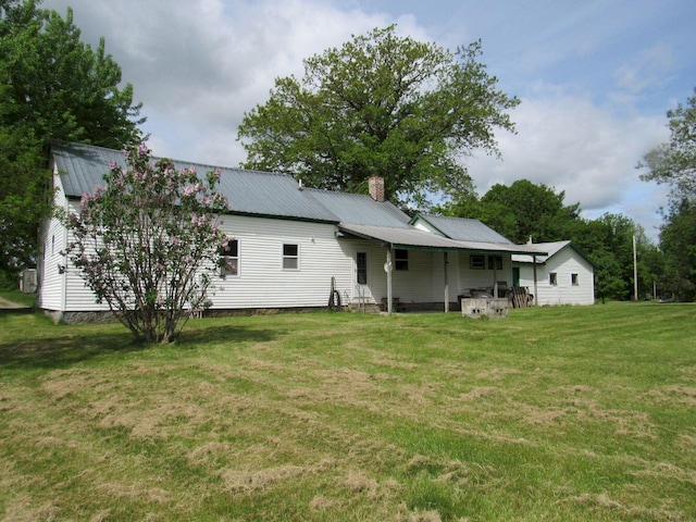 25 Moores Mill Rd, Canaan, ME 04924 - rear view of property featuring a chimney, a lawn, and metal roof