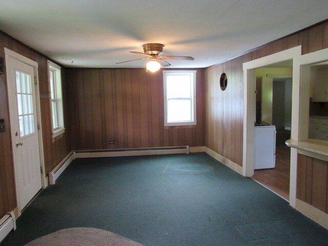 25 Moores Mill Rd, Canaan, ME 04924 - unfurnished room with wooden walls, a ceiling fan, dark carpet, baseboards, and baseboard heating