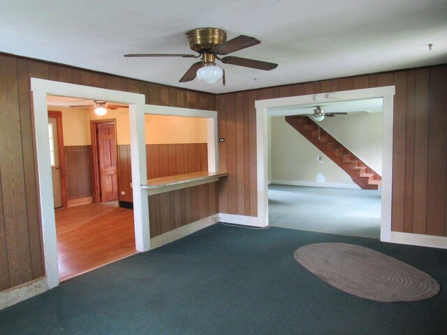 25 Moores Mill Rd, Canaan, ME 04924 - unfurnished room with wood walls, baseboards, carpet, ceiling fan, and stairs