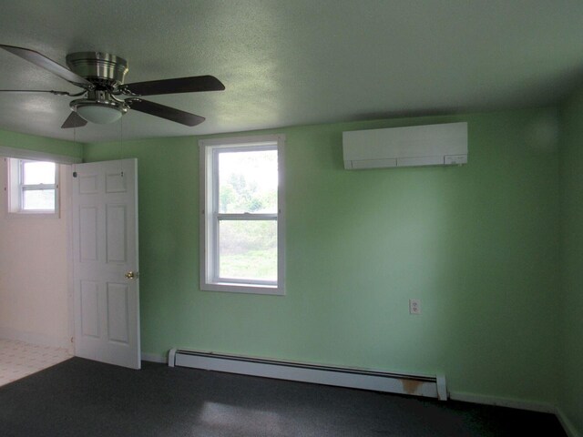 25 Moores Mill Rd, Canaan, ME 04924 - spare room featuring a wall mounted air conditioner, baseboard heating, a ceiling fan, dark colored carpet, and baseboards