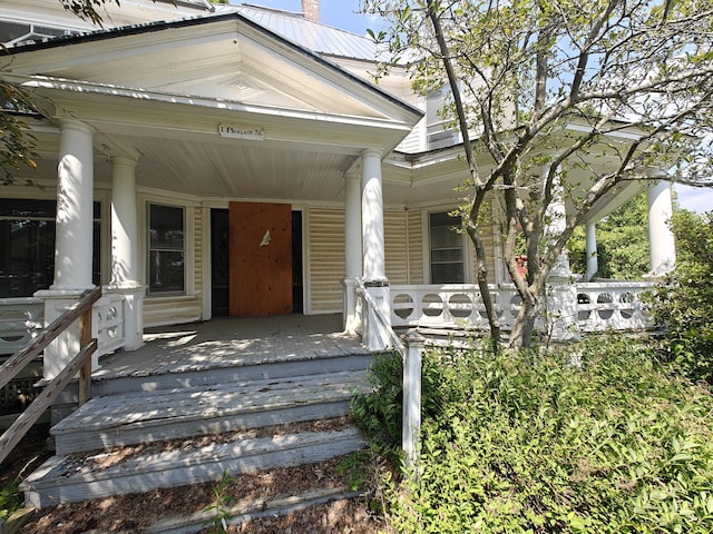 9 St Albans Rd, Corinna, ME 04928 - view of front of property with a porch, a metal roof, and a chimney