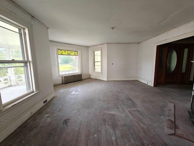 9 St Albans Rd, Corinna, ME 04928 - unfurnished living room featuring radiator, wood-type flooring, and wallpapered walls