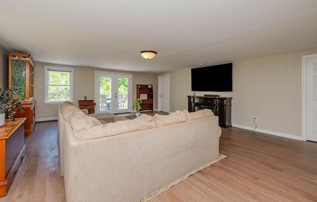59 Milton Mills Rd, Lebanon, ME 04027 - living area with baseboard heating, light wood-style flooring, baseboards, and french doors