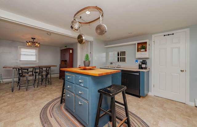 59 Milton Mills Rd, Lebanon, ME 04027 - kitchen with blue cabinets, dishwasher, wood counters, and a breakfast bar