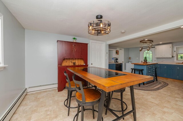 59 Milton Mills Rd, Lebanon, ME 04027 - dining room with a baseboard radiator, light floors, and a chandelier