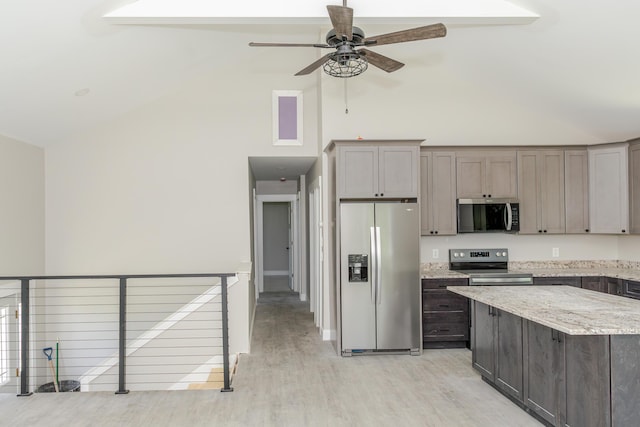 44 Bailey Rd, Cambridge, ME 04923 - kitchen with appliances with stainless steel finishes, high vaulted ceiling, light wood finished floors, ceiling fan, and light stone countertops