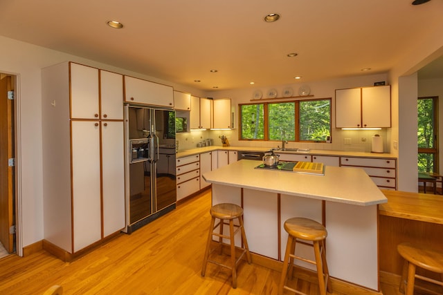 5 Spring Mountain Dr, Rockport, ME 04856 - kitchen featuring black fridge, light countertops, stovetop with downdraft, decorative backsplash, and light wood-style floors