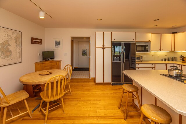 5 Spring Mountain Dr, Rockport, ME 04856 - kitchen with black appliances, light wood-style floors, light countertops, and a breakfast bar area