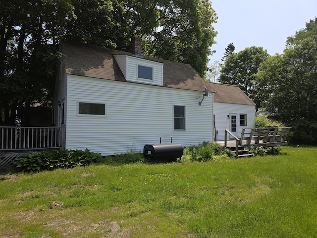 18 Cedar Ln, Belfast, ME 04915 - back of house featuring heating fuel, a wooden deck, a lawn, and a chimney