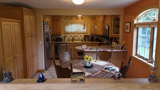 55 Pember Rd, Levant, ME 04456 - kitchen with appliances with stainless steel finishes, a sink, light tile patterned flooring, backsplash, and light countertops